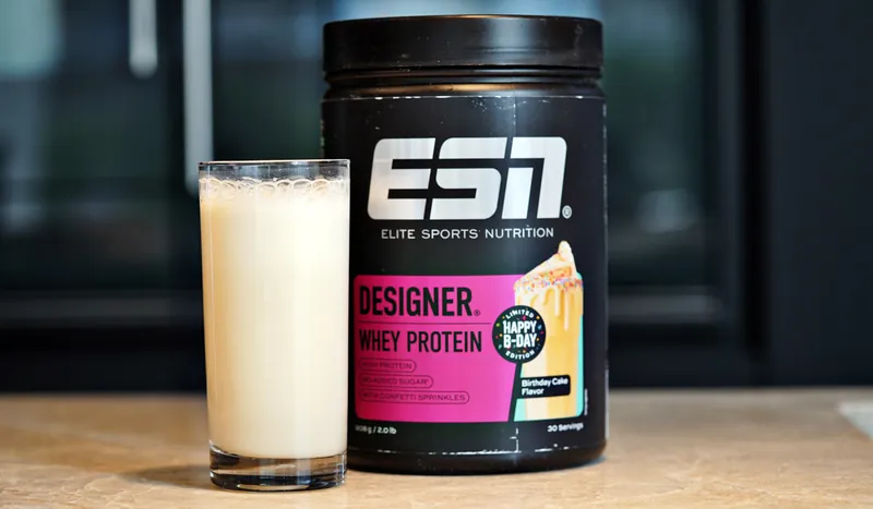 ESN Designer Whey Protein – Birthday Cake, avec un verre